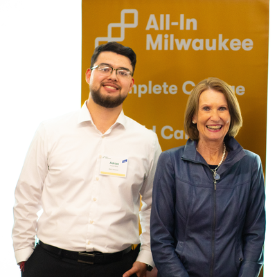 Mary Ellen Stanek standing in front of an All-In Milwaukee  banner.