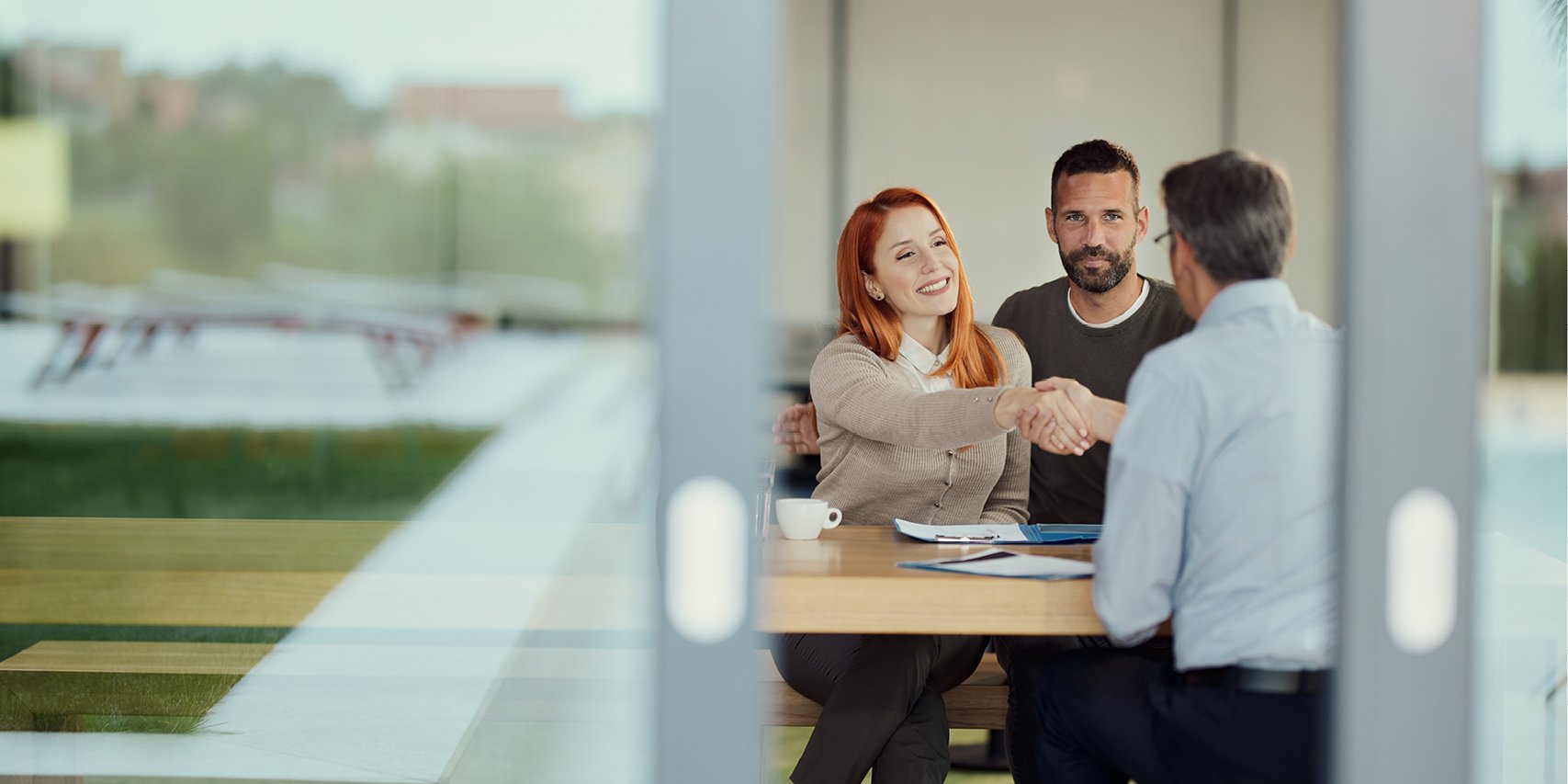 Couple meeting with an advisor while sitting at a table.