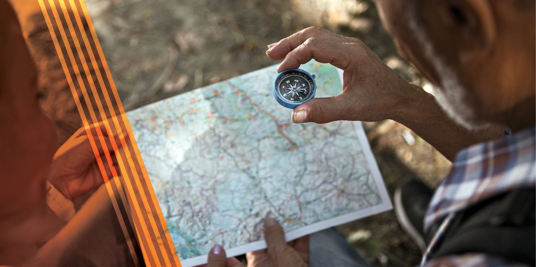 Two people looking at a compass and a map.
