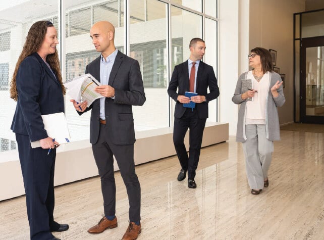 Candid photo of Baird Asset Management associates talking in a hallway 