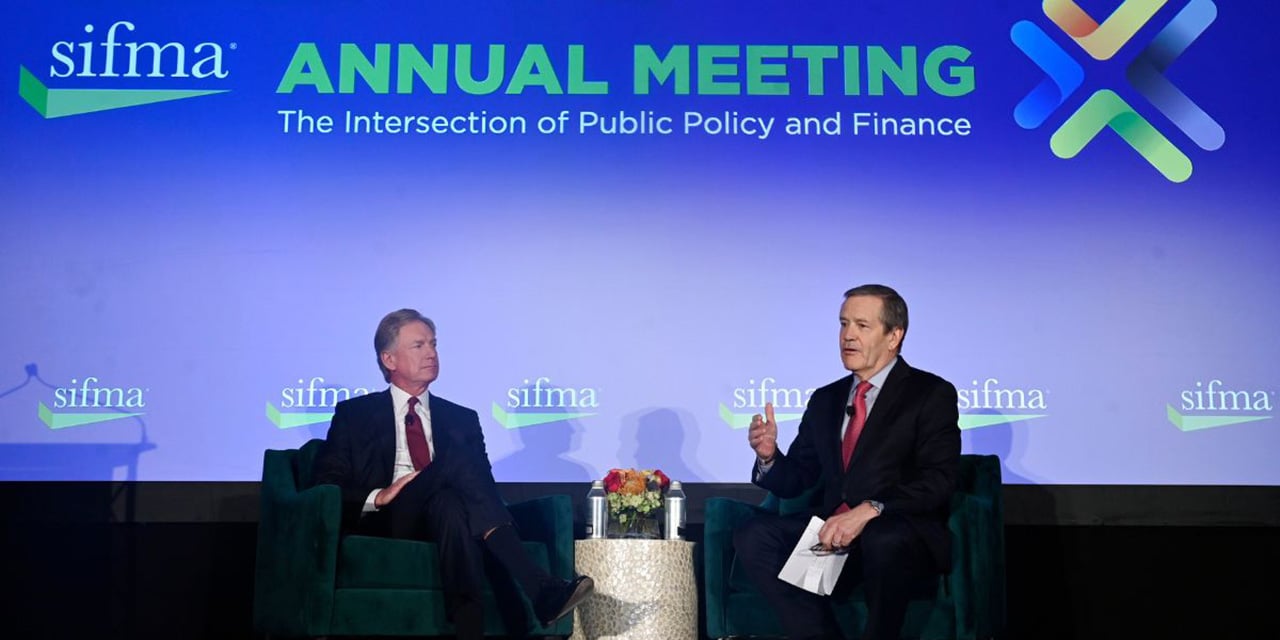 Steve Booth and John Taft sitting on stage at the SIFMA annual meeting.