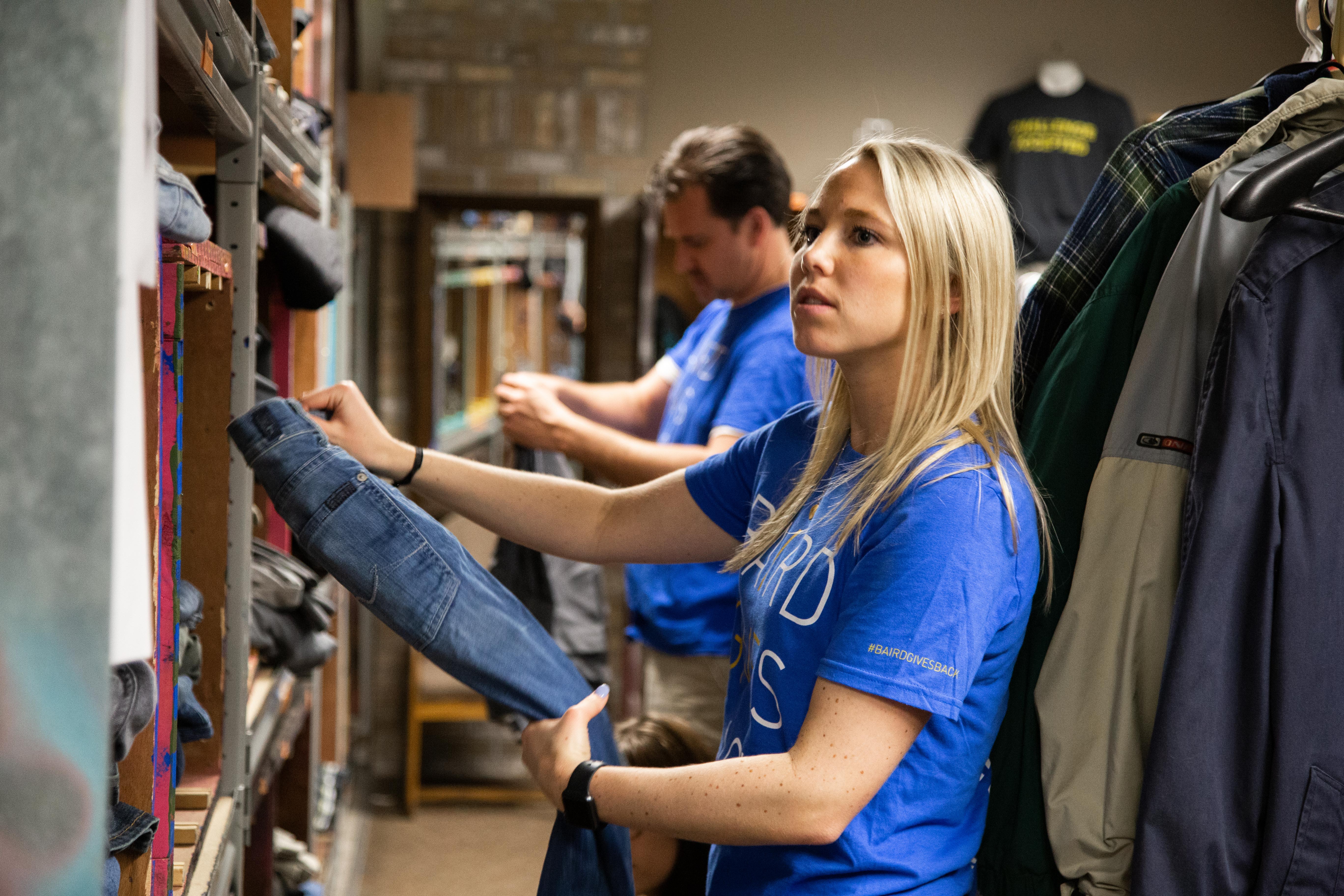 Baird Asset Management associates organizing clothes at Pathfinders