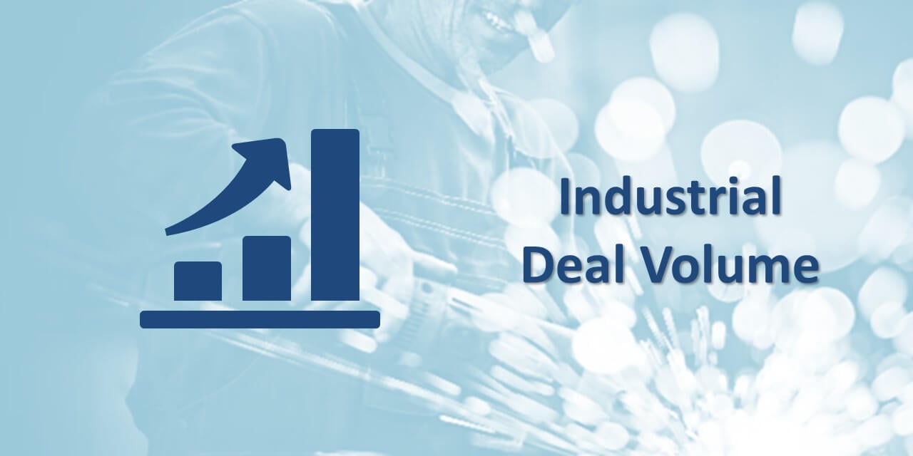 An icon of an increasing bar graph with the words, "Industrial Deal Volume" against a faded photo of a person doing industrial work