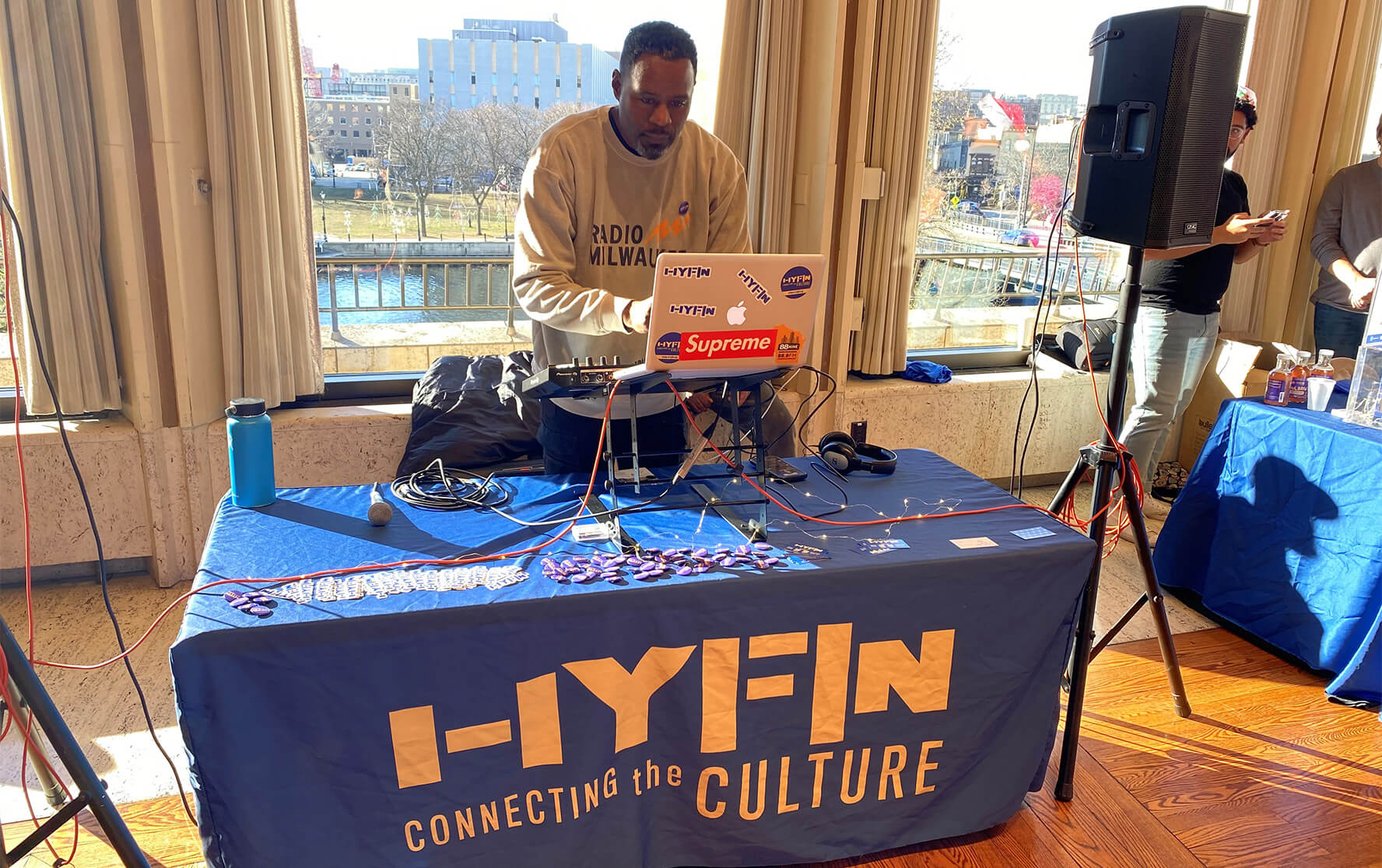 A DJ plays music from the Radio Milwaukee booth at the HYFIN  inaugural Black holiday market