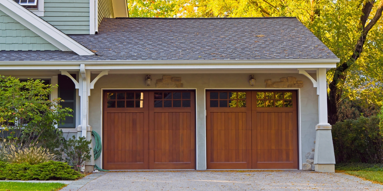 Photo of a four car garage with wooden doors.
