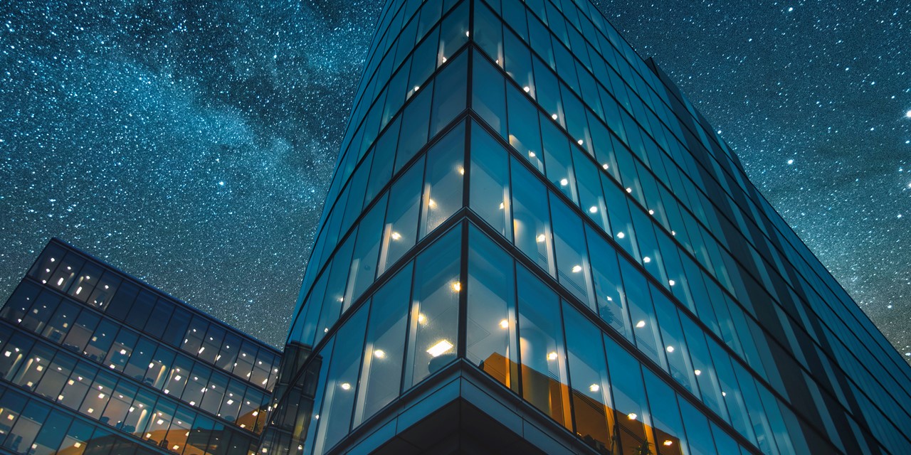 Office building with stars in the sky above at night