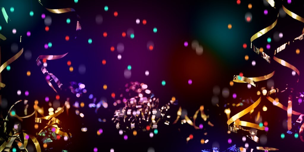 abstract image of colorful confetti and ribbons falling against a blurred background