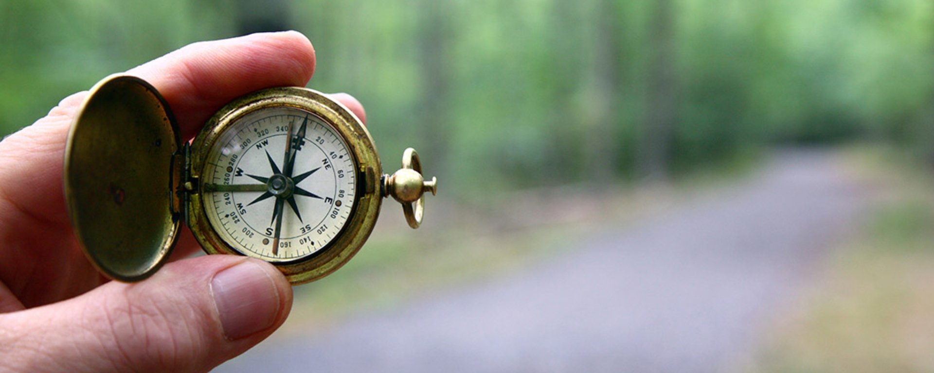 Hand holding a compass.