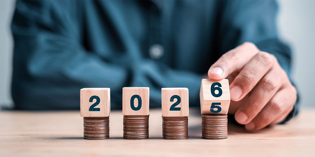 Hand holding blocks with the numbers 2026 on the blocks.