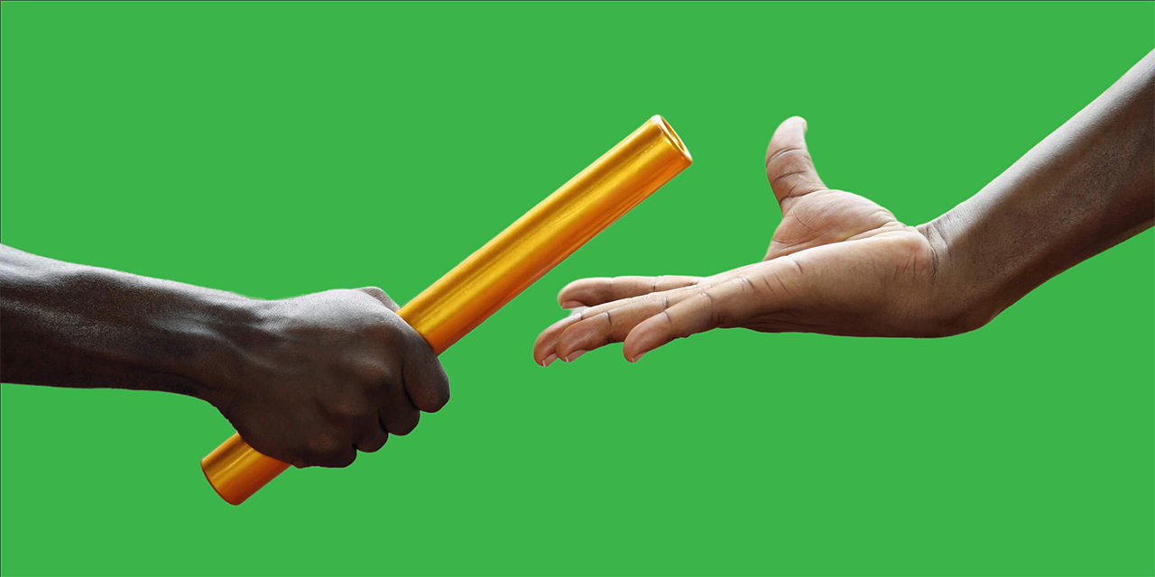 Close-up photo of the handoff of a relay race batton