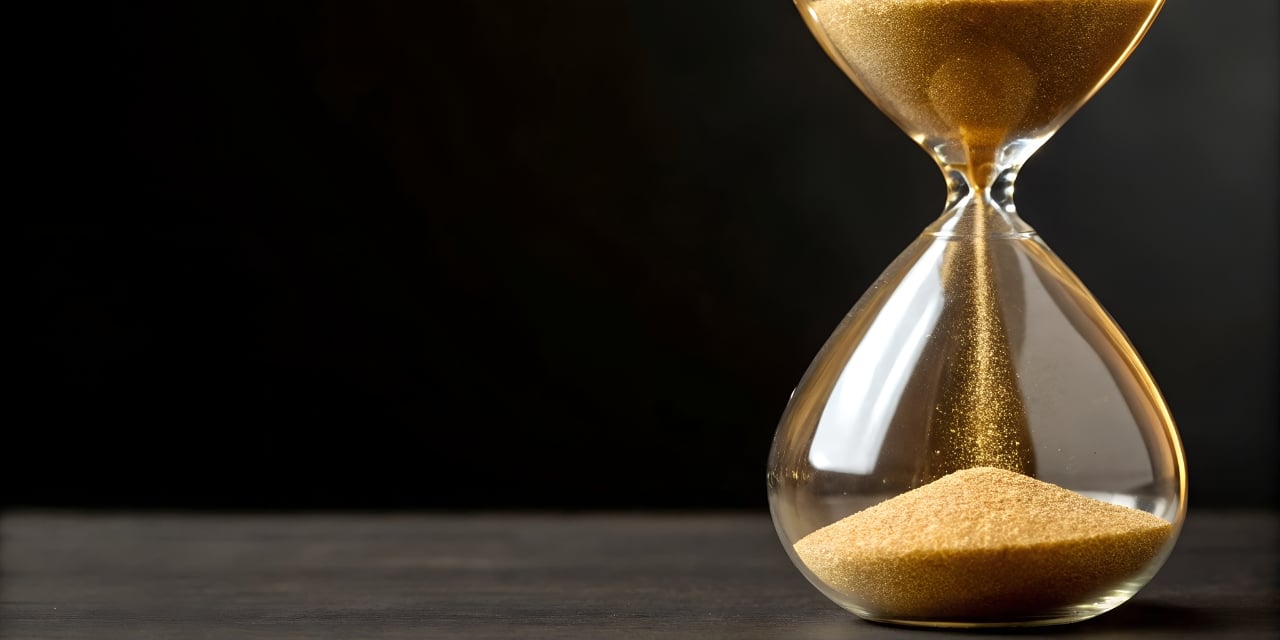 Hourglass with gold sand pouring into the bottom chamber.