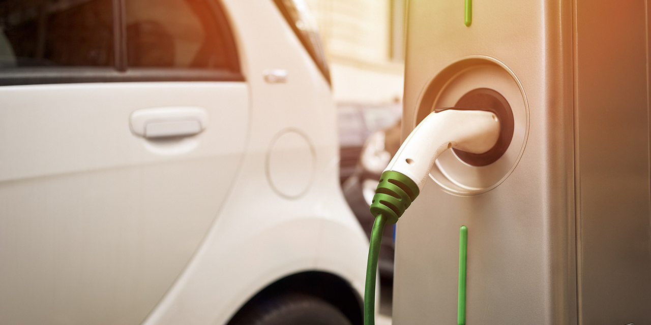 Image of an electric car plugged into a charger. 