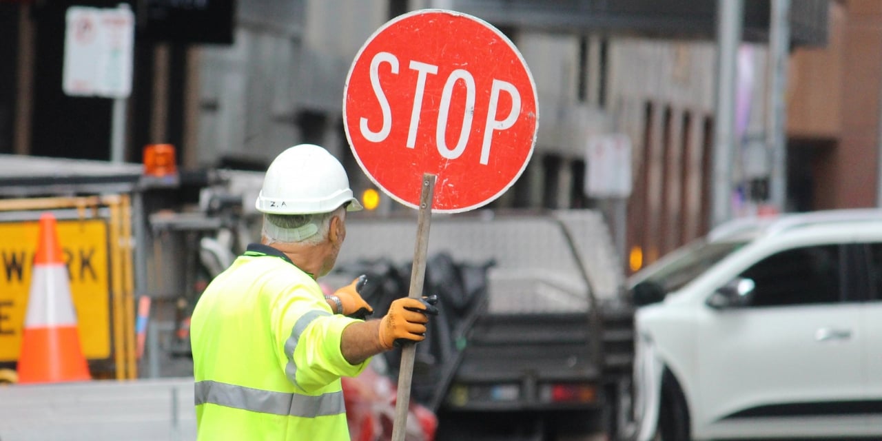 Man holding a stop sign to direct traffic during road construction