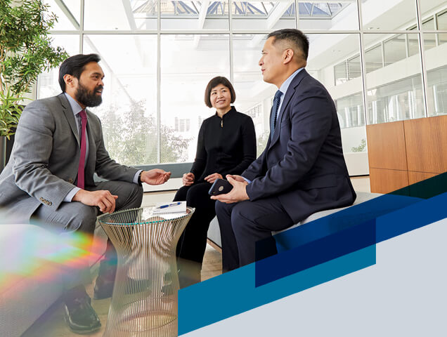 Three associates from the Chautauqua team engaged in conversation in an open office area