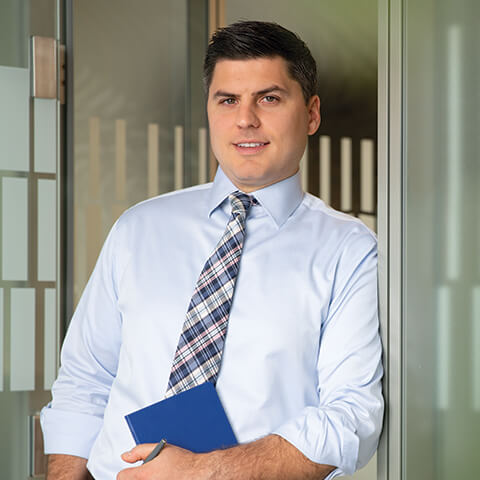 Photo of an Equity Capital Markets associate holding a notebook and smiling in a conference room doorway