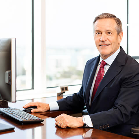 A photo of John Taft smiling while sitting at his computer