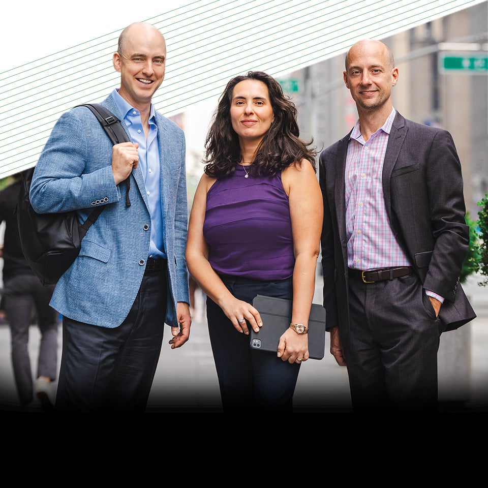 Three associates from Equities Capital Markets standing outside office buildings