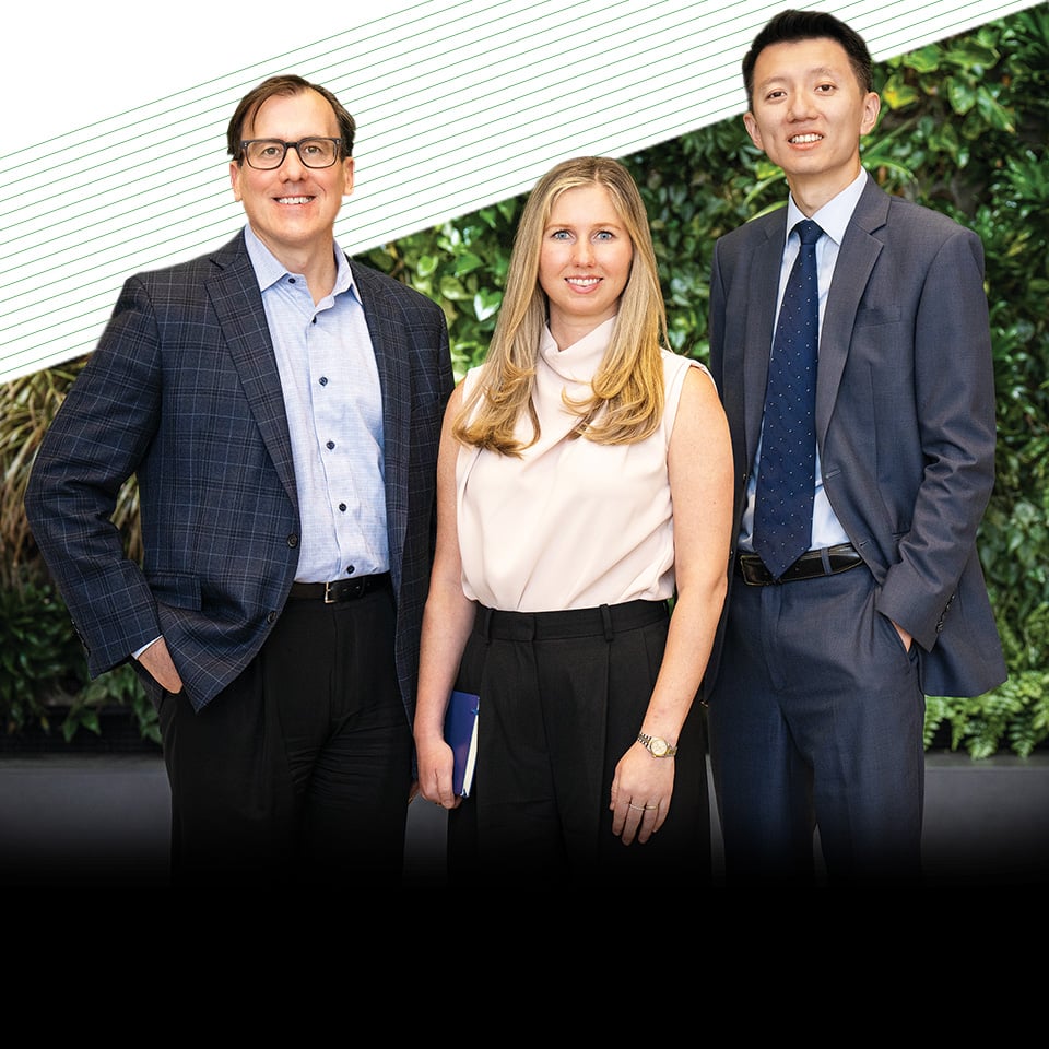 Three associates from Baird Principal Investments in front of a garden wall
