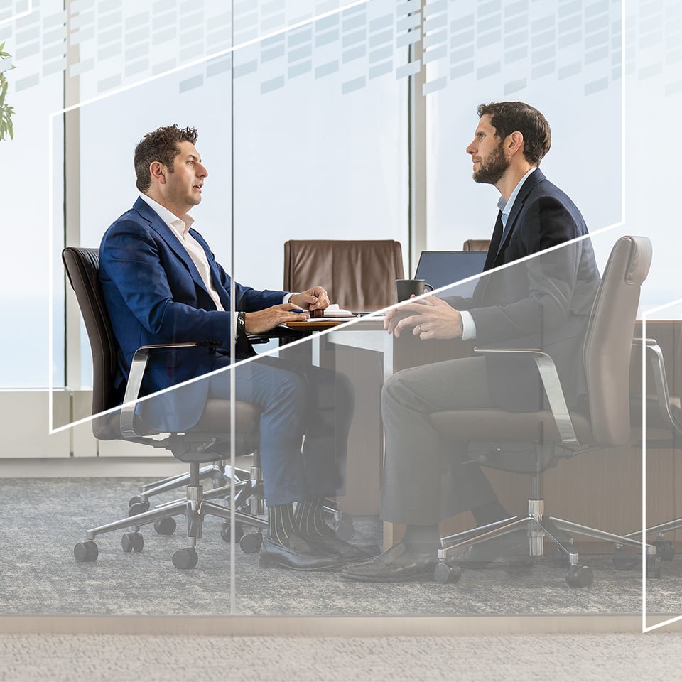 Two associates from Baird Fixed Income Capital Markets having a discussion in a conference room
