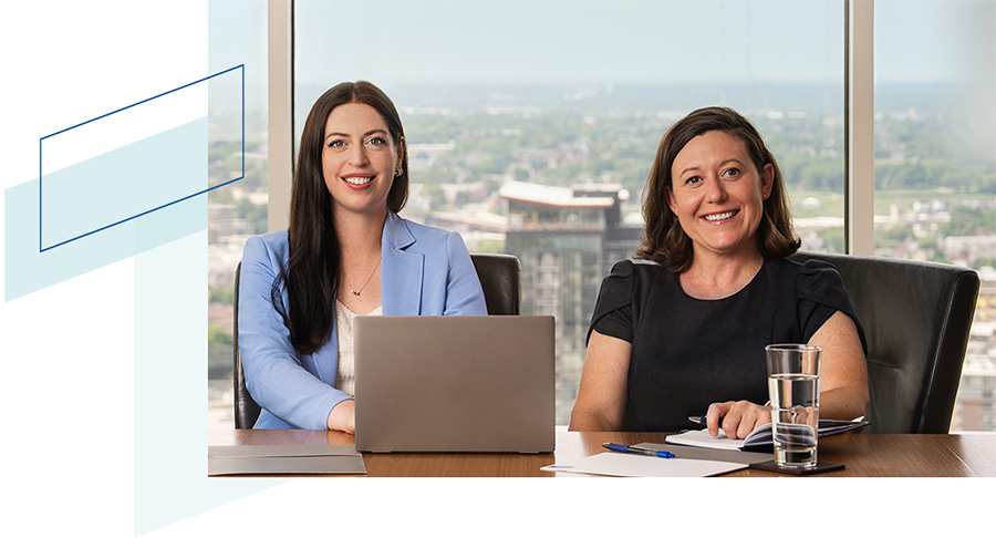 Two Baird CRG associates sitting in an office conference room overlooking Milwaukee