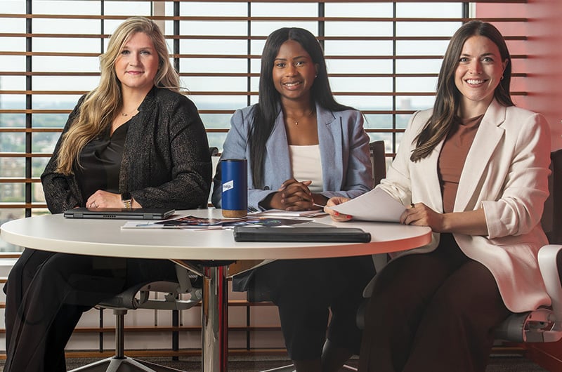 Three associates from Baird's Corporate Events team around a small conference room table