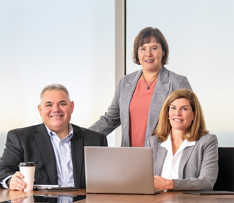 Three Baird Private Wealth Management associates at a table in an office setting