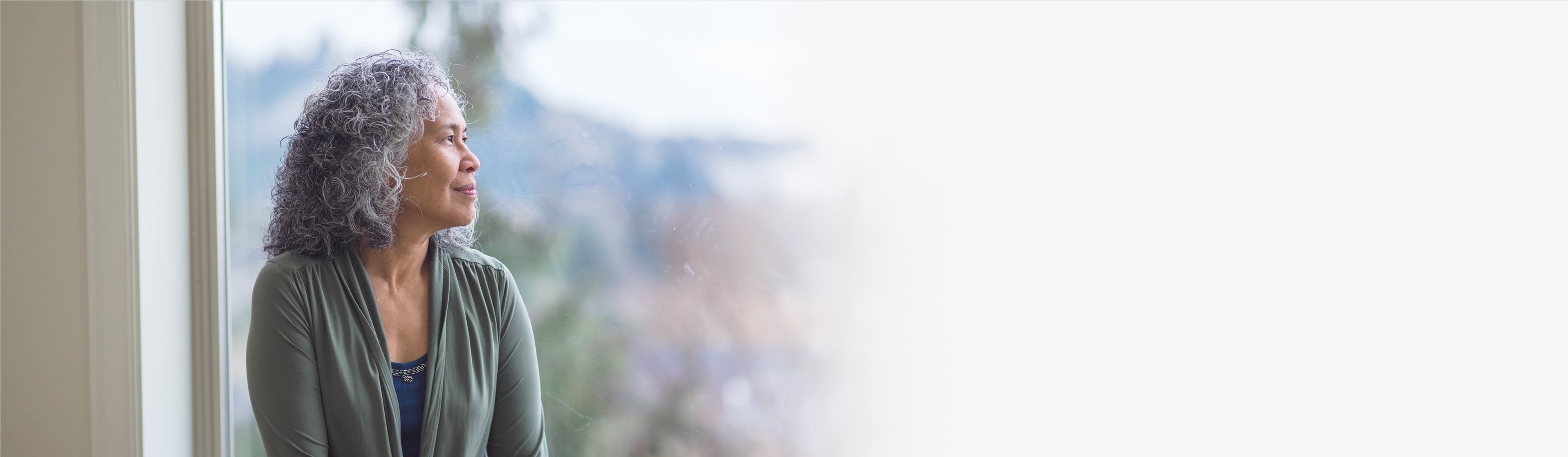 Woman looking out large window