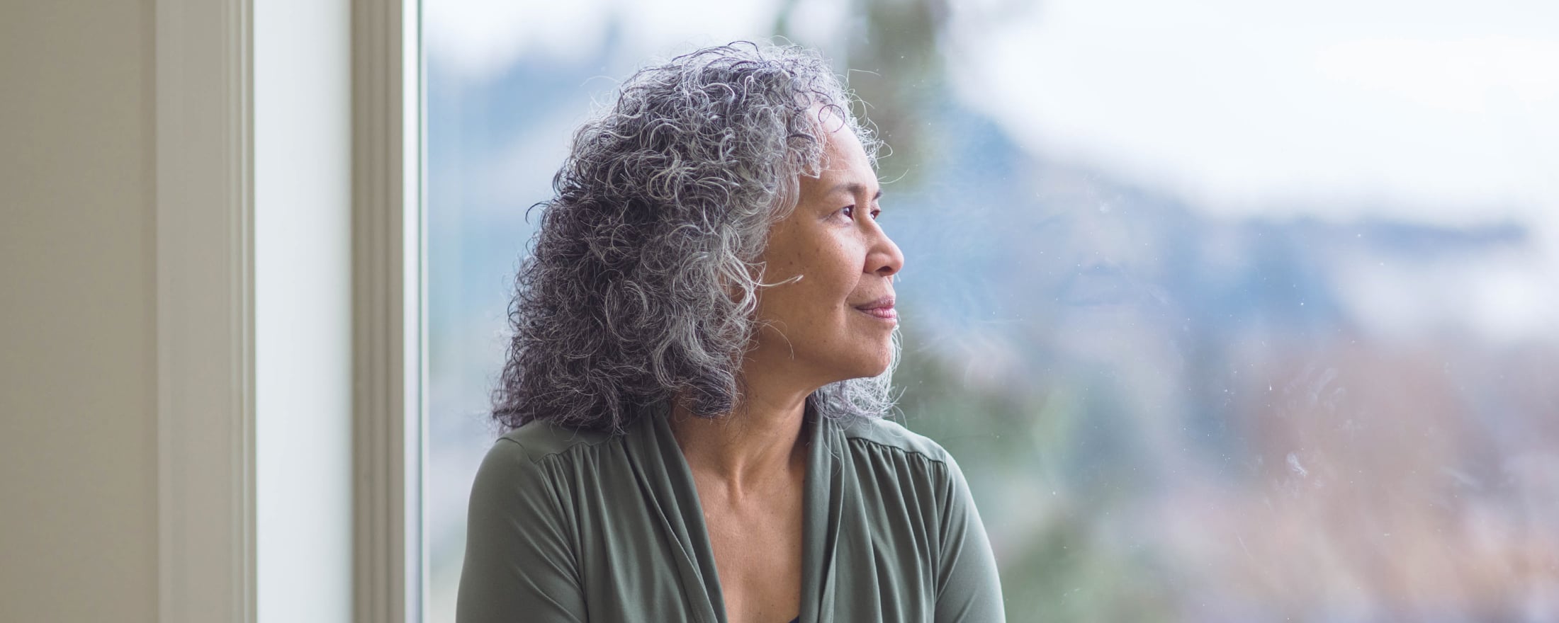 Woman looking out large window