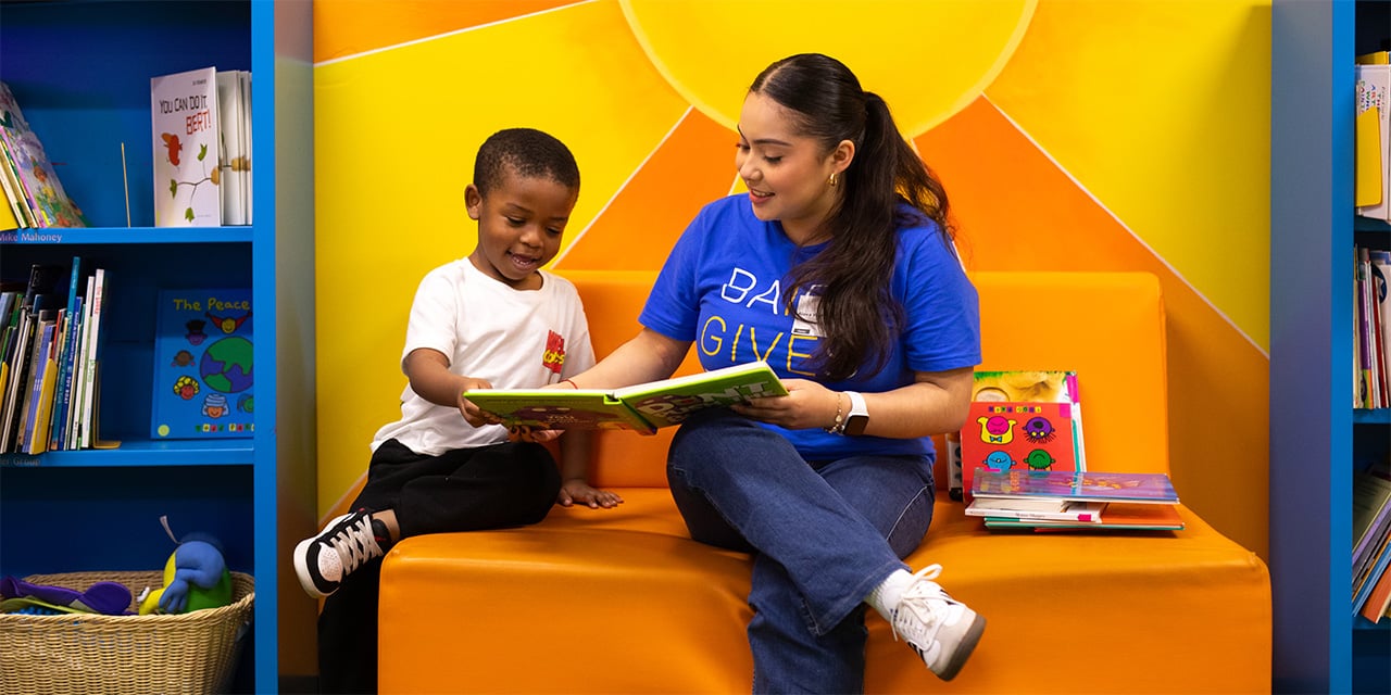 A Baird associate reading with a child at a volunteer event during Baird Gives Back Week