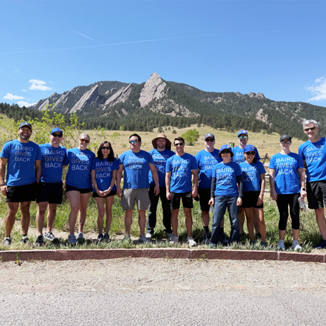 Sharp group photo with strong outdoor setting and mountain backdrop.