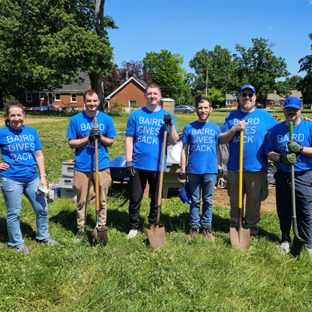Strong outdoor group portrait with tools and purpose.