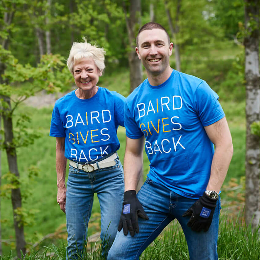 Kim Fleming and Max Mann wearing Baird Gives Back t-shirts during an outdoor volunteer event
