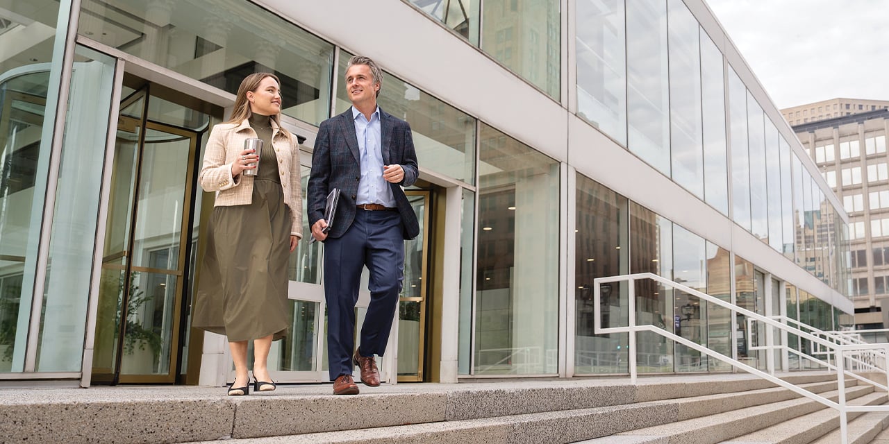 Two business professionals walking out of an office building