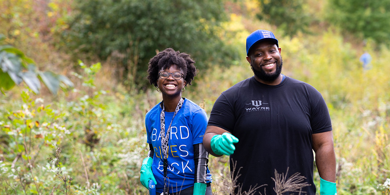 Woman and man working together at an outdoor cleanup event.