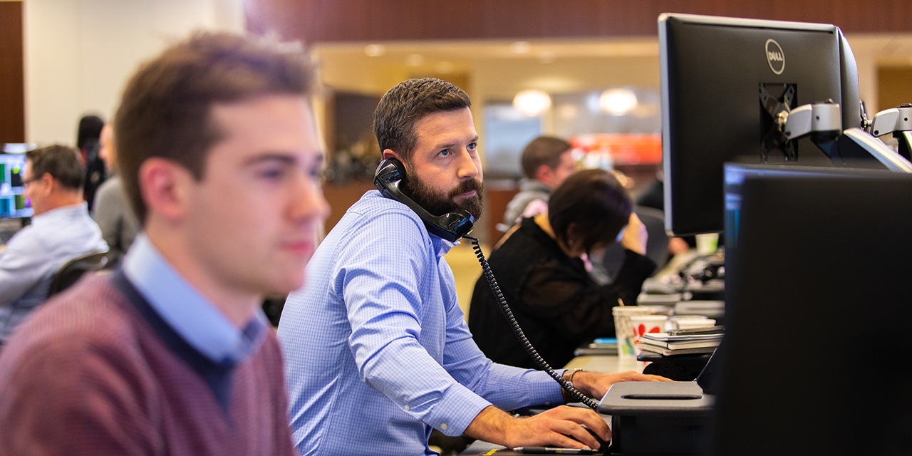 Professional talking on telephone while sitting in front of a computer