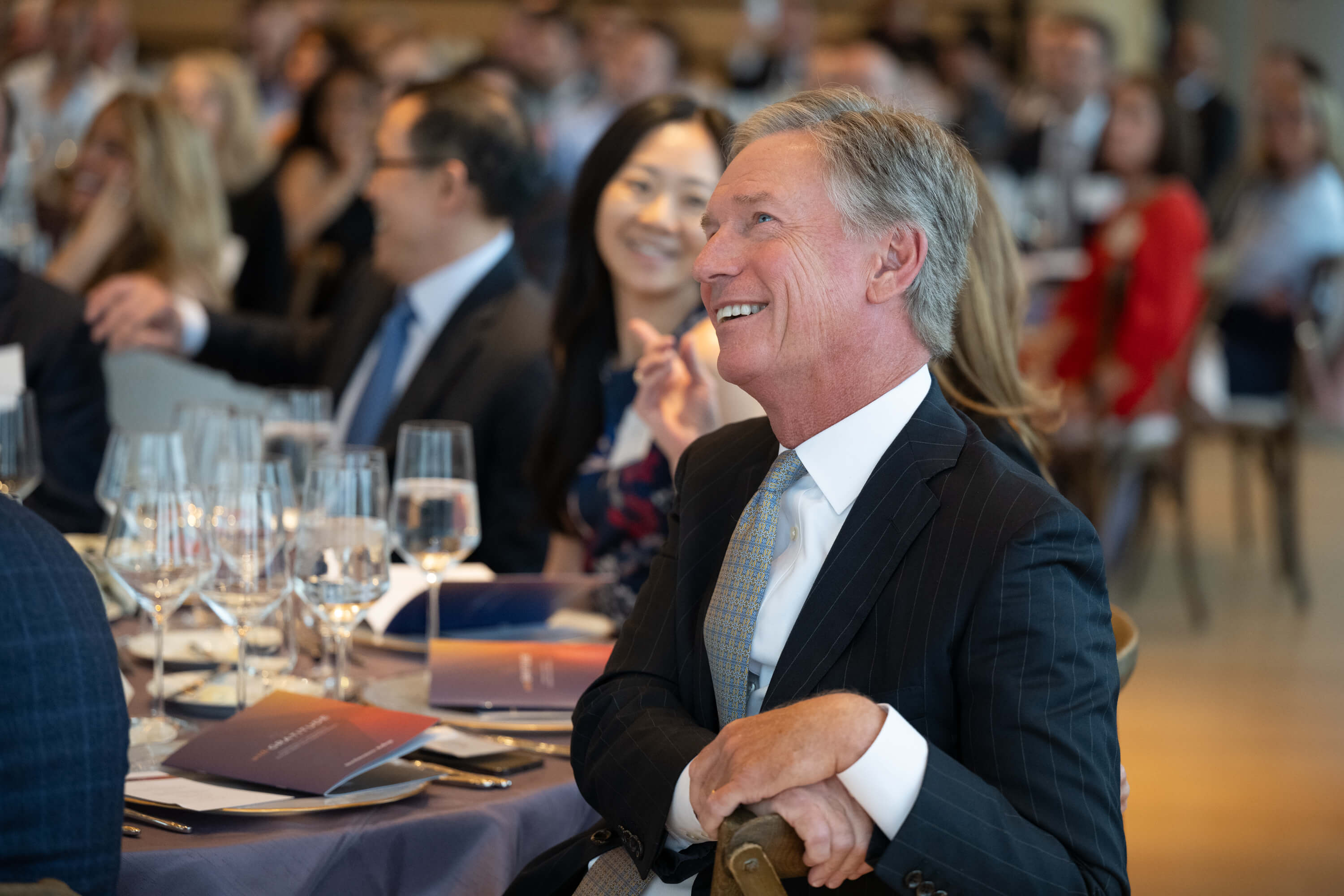 Steve Booth smiling in the audience of the Kellogg School of Management at Northwestern University's annual "With Gratitude" event on May 2, 2024
