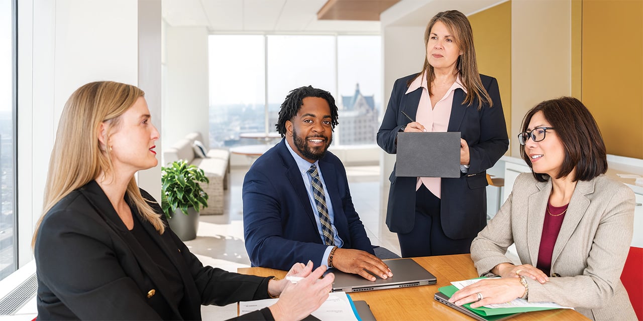 Four Baird associates around a conference table