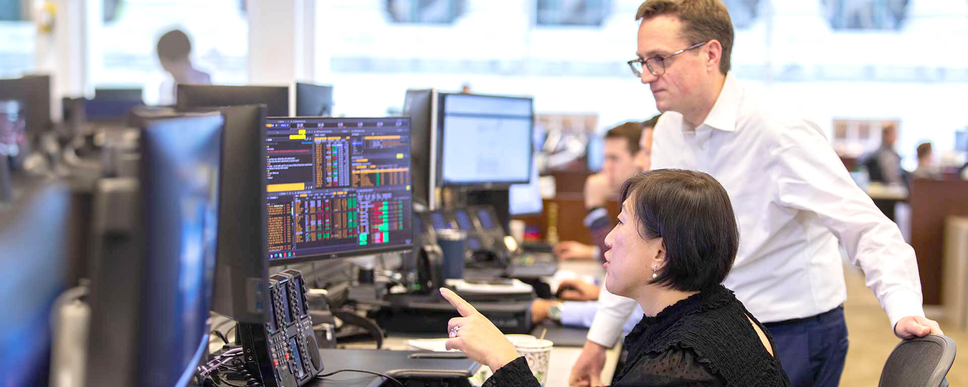 Two Baird associates viewing a computer screen  on the trading floor