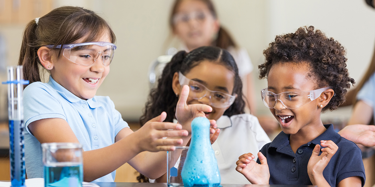 Elementary school children conducting a science experience while wearing protective eyewear.