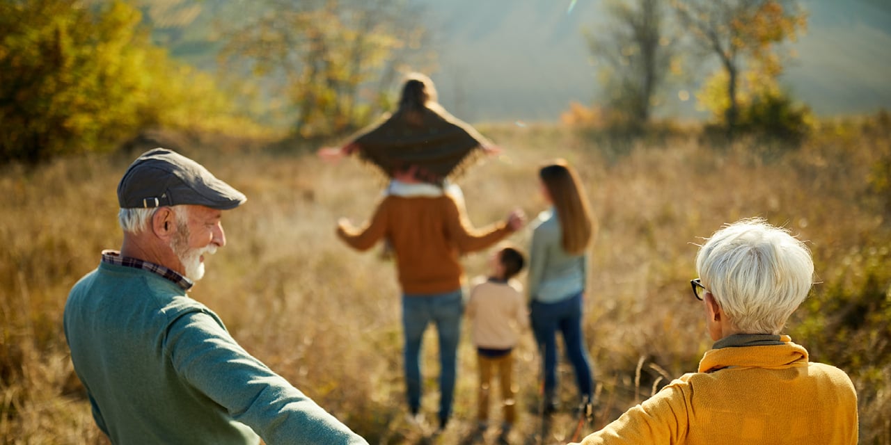 Generational family walking through a prairie in the fall.