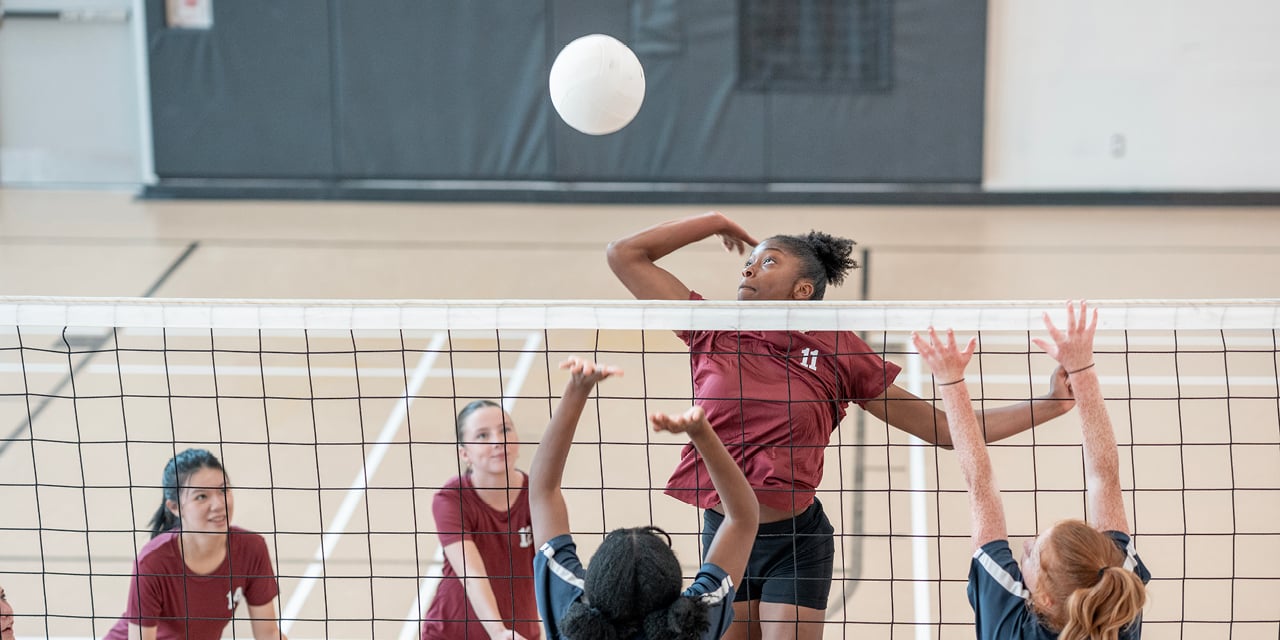 Women playing volleyball in a gym