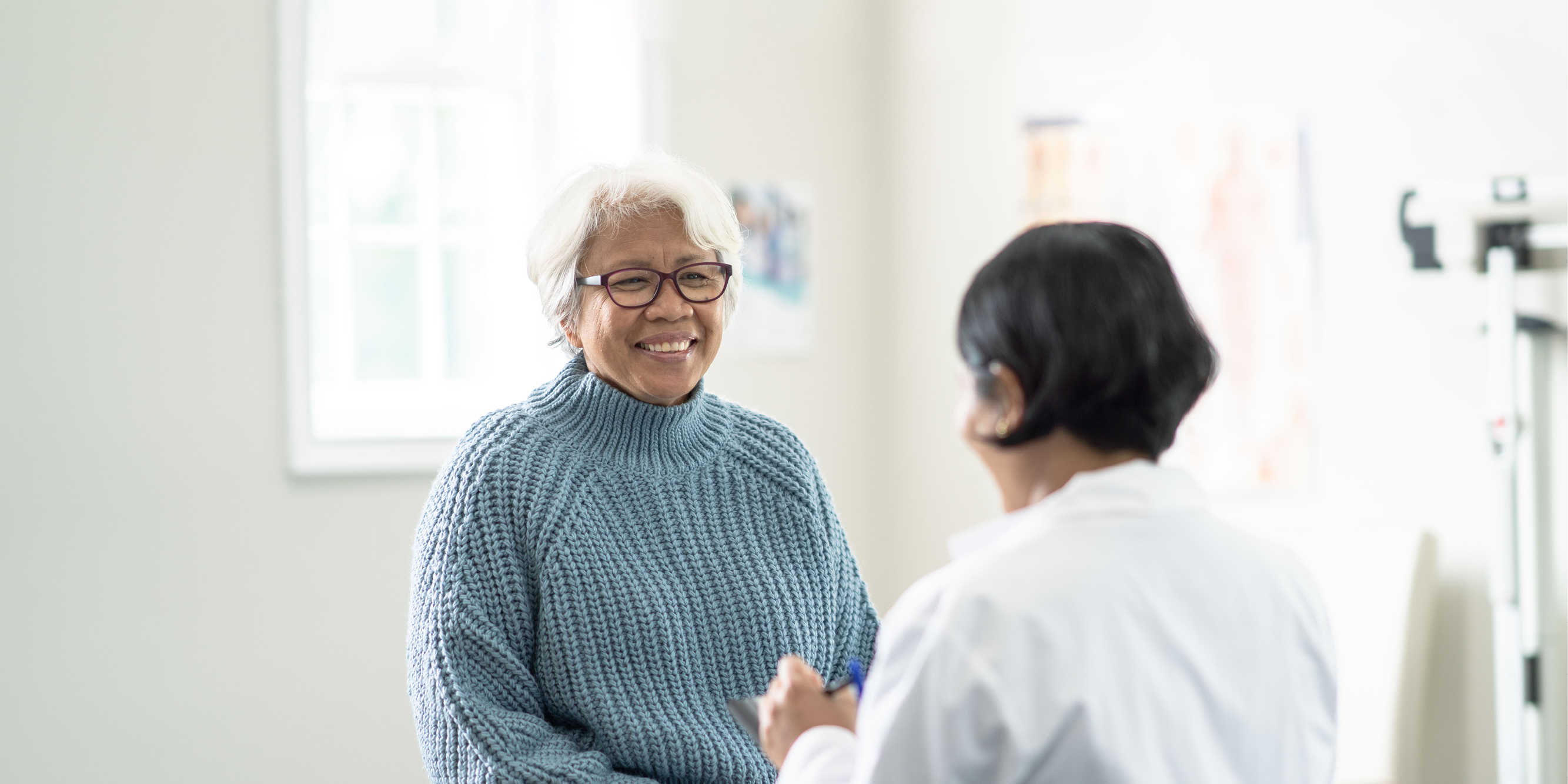 Older woman talking to a doctor.