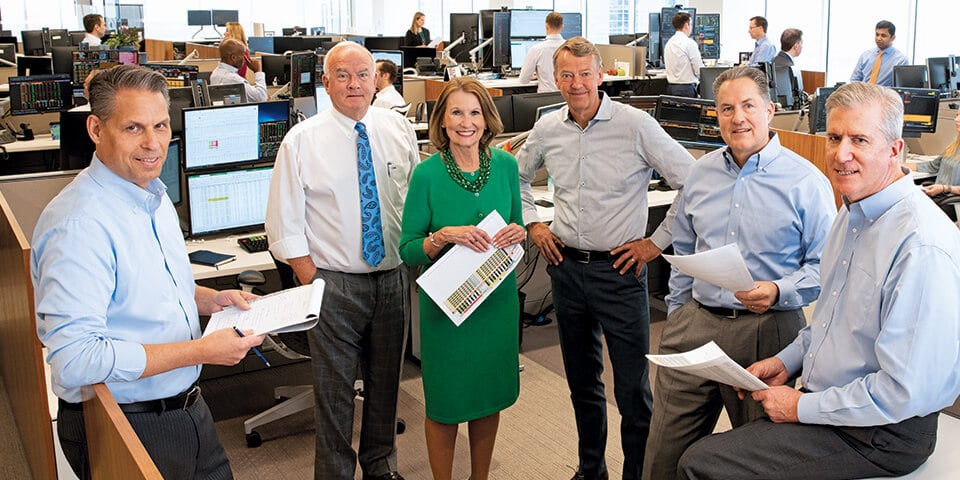 A photo of the Asset Management team featuring Mary Ellen Stanek with the Baird Milwaukee office trading floor in the background