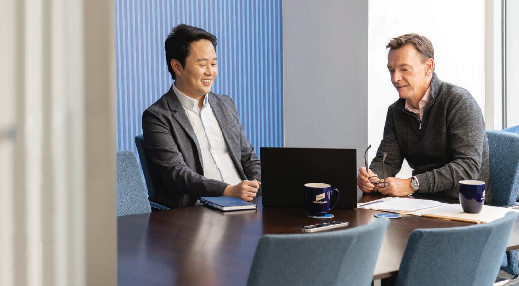 Two Principal Investments associates reviewing information on a laptop