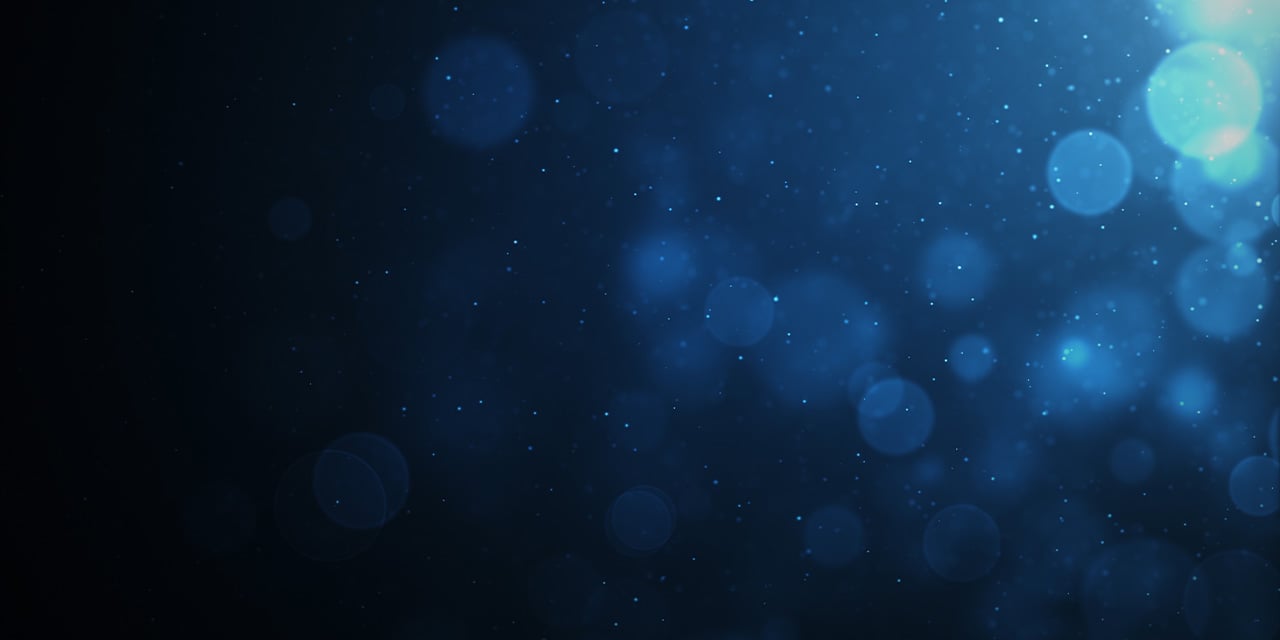 Soft blue bokeh lights scattered across a dark background creating a glowing, abstract effect.
