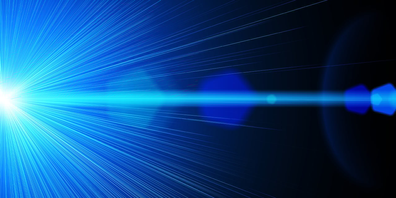 Bright blue light beam with radiating rays and lens flares against a dark background.