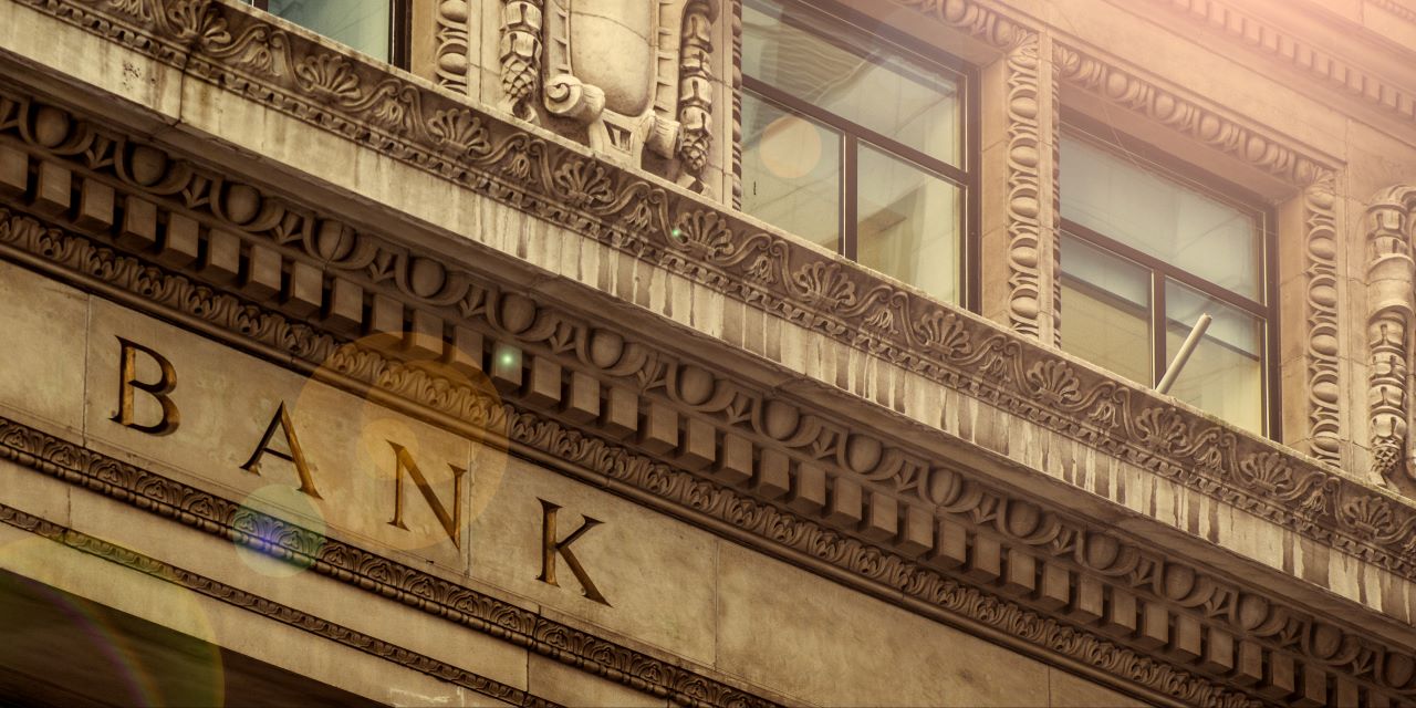 Exterior view of a bank building showing the word bank carved into stone.