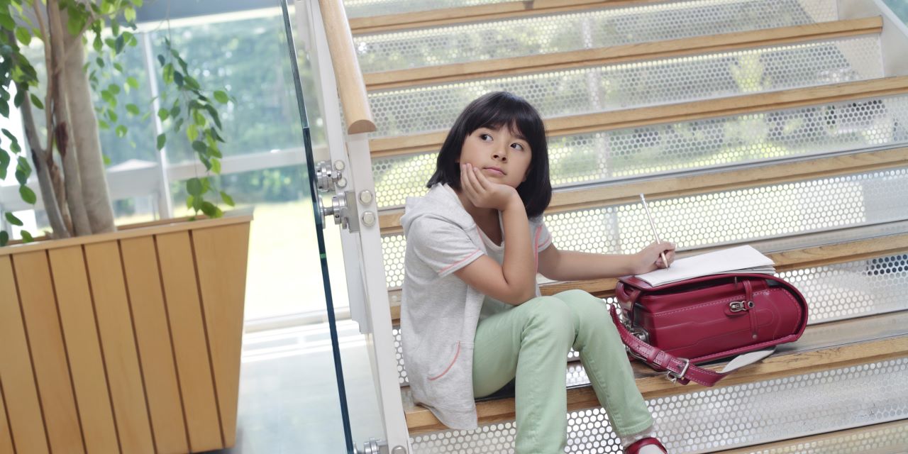 School-age girl thinking thoughtfully in classroom