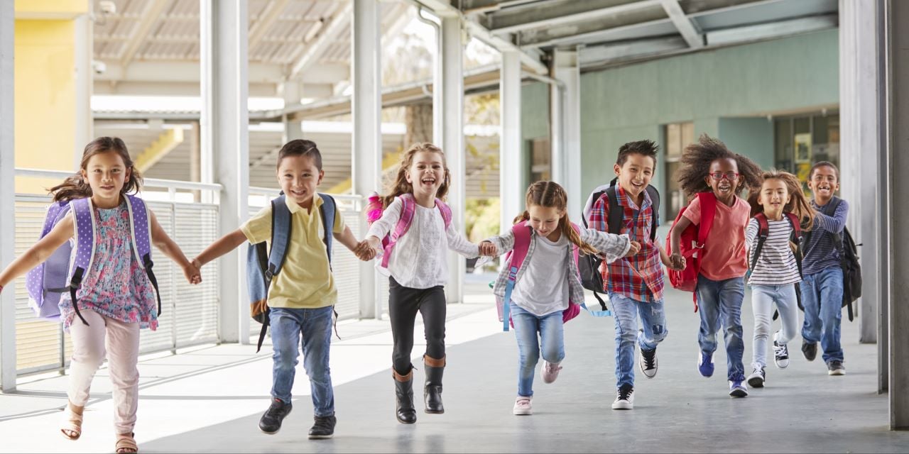 Children holding hands and running outdoors