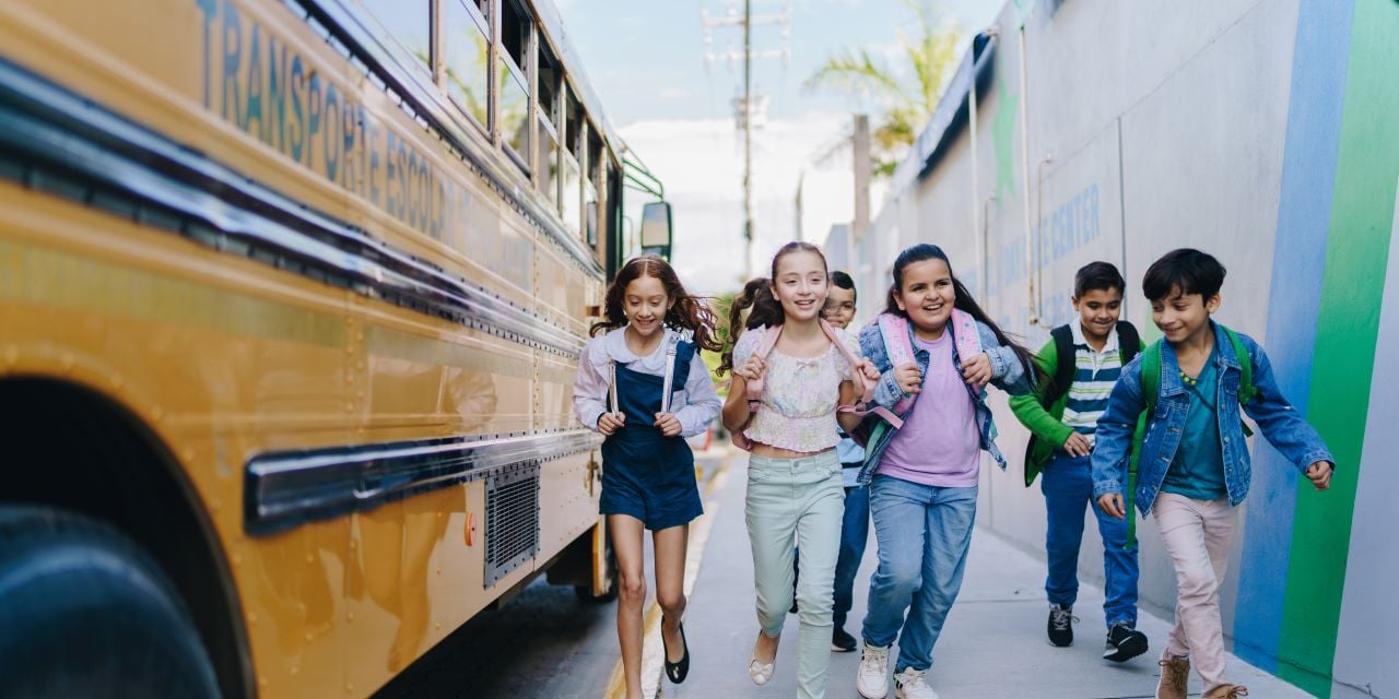 Children running toward a school bus